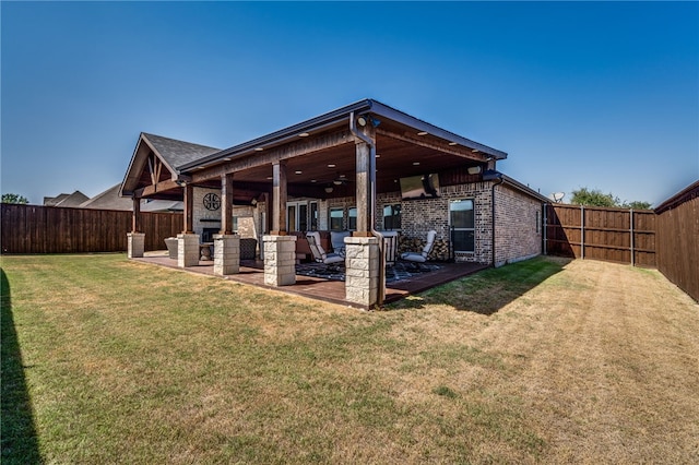 rear view of property with ceiling fan, a yard, and a patio