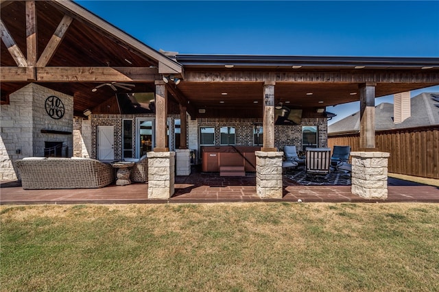 view of patio / terrace featuring ceiling fan, a fireplace, and a jacuzzi