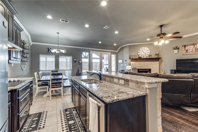 kitchen with a kitchen island with sink, sink, crown molding, and black electric stovetop