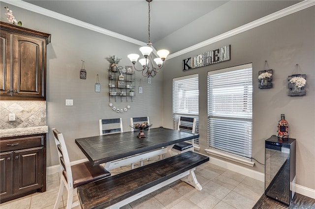 dining area featuring light tile patterned floors, ornamental molding, and a notable chandelier