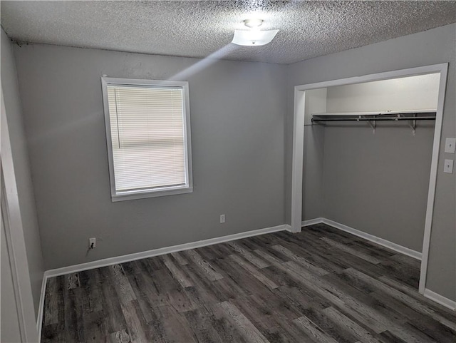 unfurnished bedroom with a textured ceiling, a closet, and dark wood-type flooring