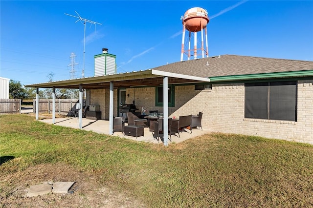 rear view of house featuring an outdoor living space, a patio area, and a lawn