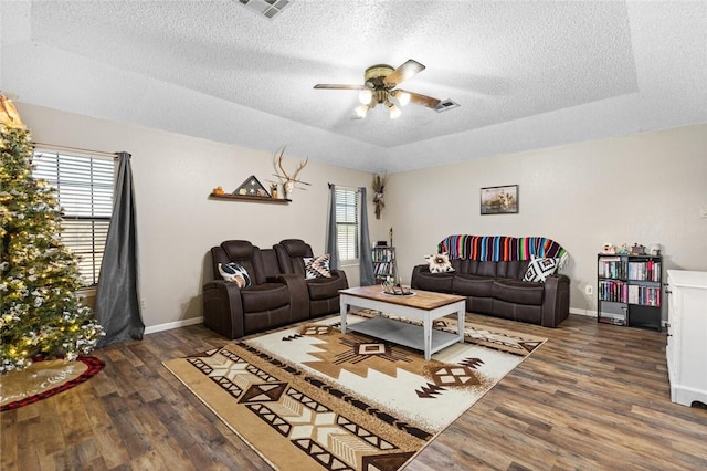 living room with a textured ceiling, a wealth of natural light, ceiling fan, and dark hardwood / wood-style floors