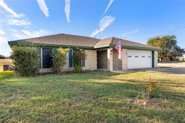 ranch-style home with a garage, a front lawn, and central air condition unit