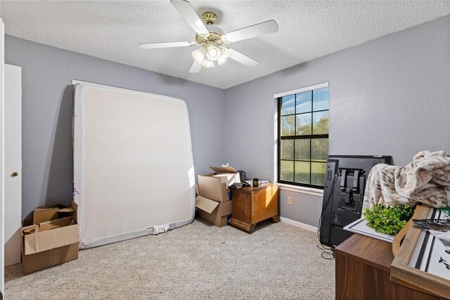 office space with ceiling fan, light colored carpet, and a textured ceiling