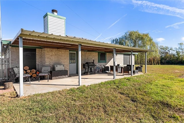 back of property with a patio area and a lawn