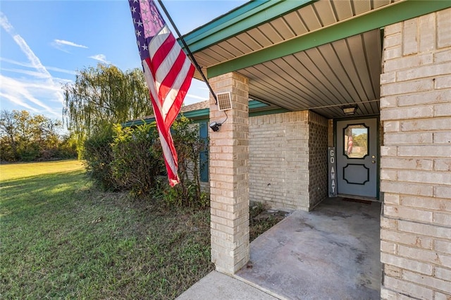 view of exterior entry featuring a yard