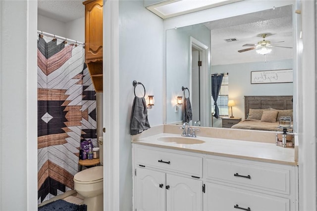 bathroom featuring ceiling fan, a textured ceiling, toilet, vanity, and a shower with shower curtain