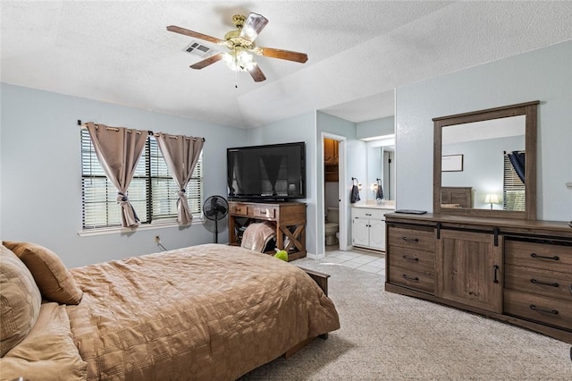 carpeted bedroom with vaulted ceiling, ensuite bathroom, ceiling fan, and a textured ceiling