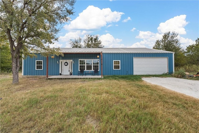 view of front facade with covered porch, a front yard, and a garage