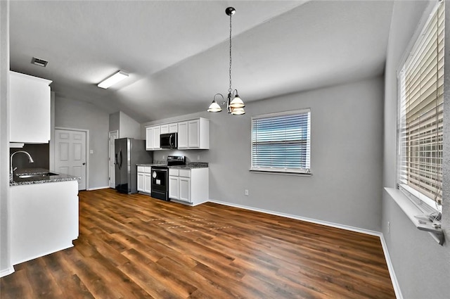 kitchen featuring lofted ceiling, sink, white cabinetry, stainless steel appliances, and a chandelier