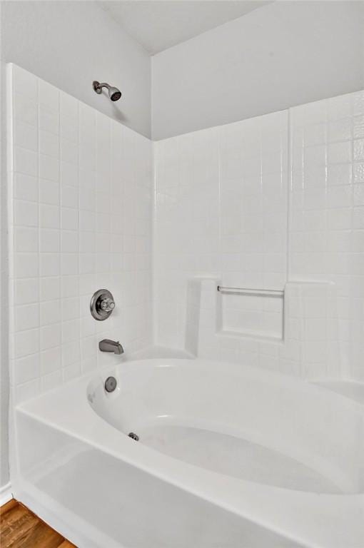 bathroom featuring hardwood / wood-style floors and shower / washtub combination