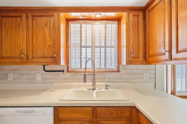 kitchen with tasteful backsplash, white dishwasher, and sink