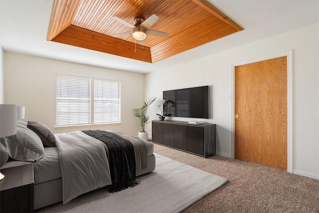 bedroom featuring light carpet, wooden ceiling, ceiling fan, and a tray ceiling