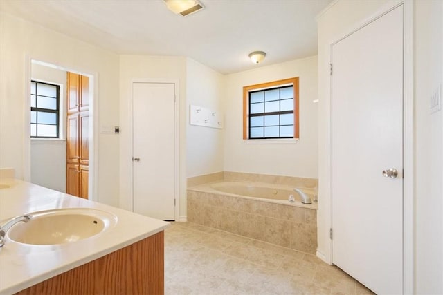 bathroom with vanity and a relaxing tiled tub