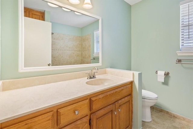 bathroom with tile patterned flooring, vanity, a healthy amount of sunlight, and toilet