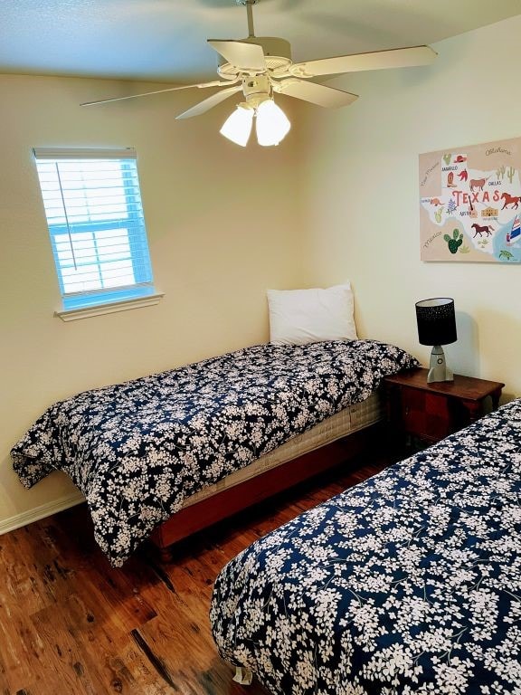 bedroom with ceiling fan and dark hardwood / wood-style flooring