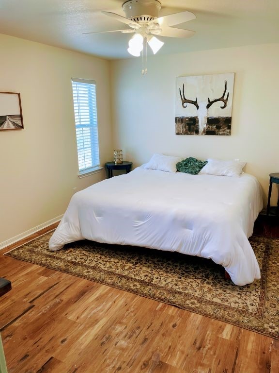 bedroom with ceiling fan and wood-type flooring