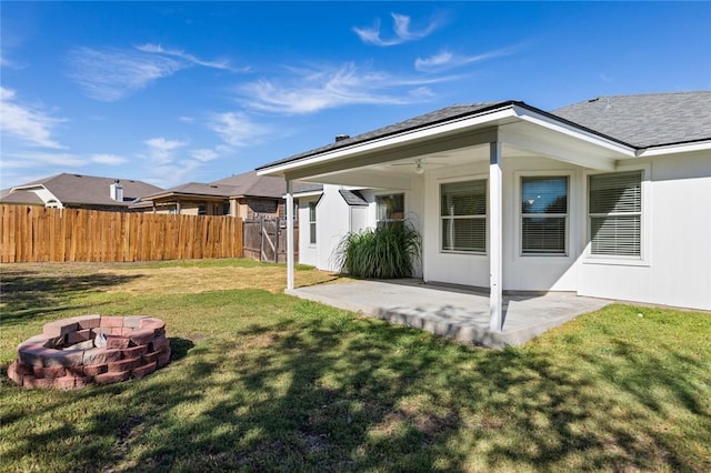 back of house with a lawn, ceiling fan, an outdoor fire pit, and a patio