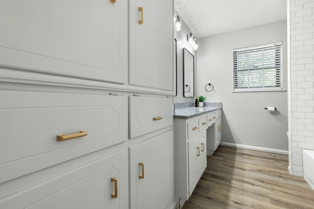 bathroom featuring a textured ceiling, vanity, and hardwood / wood-style flooring