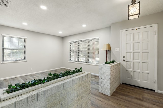 foyer featuring a textured ceiling and dark wood-type flooring