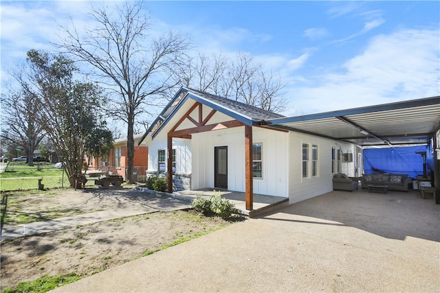 view of front of property with a carport, fence, and board and batten siding