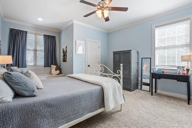 carpeted bedroom with ceiling fan, crown molding, and baseboards