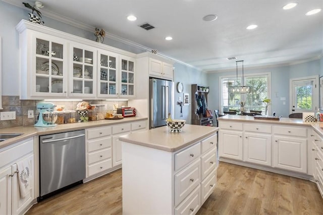 kitchen with stainless steel appliances, visible vents, light wood-style flooring, and white cabinets