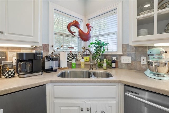 kitchen with a sink, stainless steel dishwasher, white cabinetry, light countertops, and dishwasher