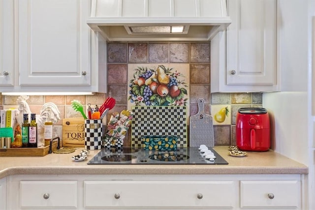 kitchen featuring electric cooktop, custom range hood, tasteful backsplash, white cabinets, and light countertops