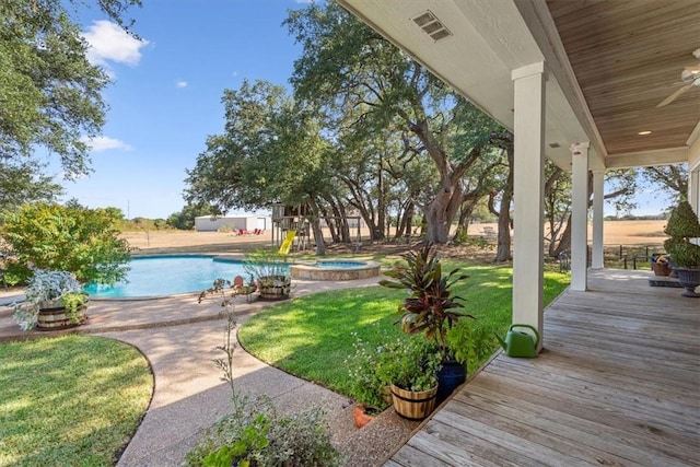 view of yard featuring visible vents and a pool with connected hot tub