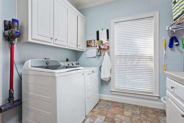 washroom with baseboards, cabinet space, washing machine and dryer, and stone finish floor