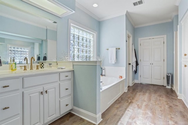 bathroom featuring a garden tub, crown molding, and wood finished floors