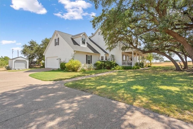 view of front of home with driveway, an attached garage, covered porch, and a front yard