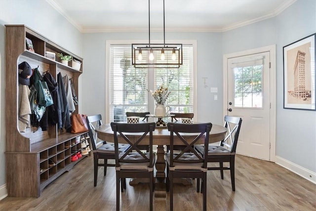 dining room with wood finished floors, baseboards, and ornamental molding