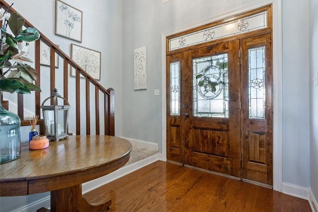 entrance foyer with stairs, baseboards, and wood finished floors