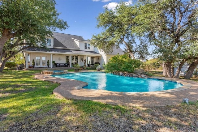 view of swimming pool with french doors, a patio, a lawn, and a pool with connected hot tub