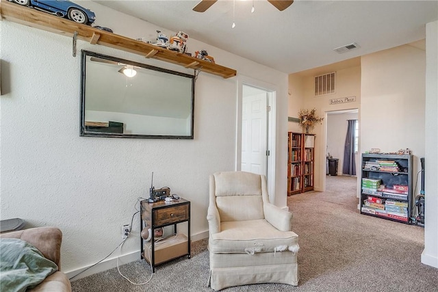 living area featuring ceiling fan and carpet