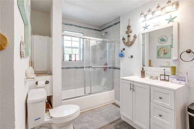 full bathroom featuring vanity, toilet, and bath / shower combo with glass door