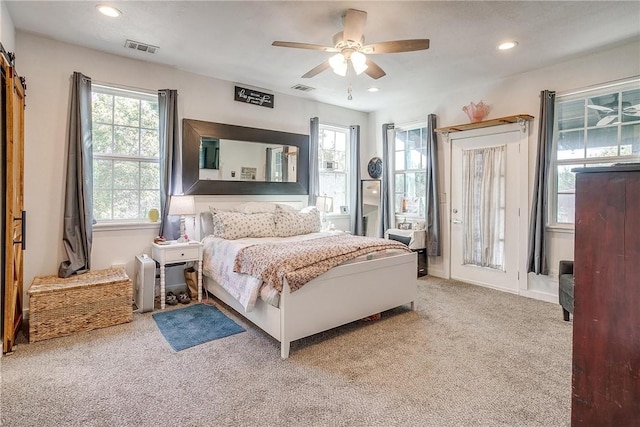 carpeted bedroom featuring multiple windows and ceiling fan