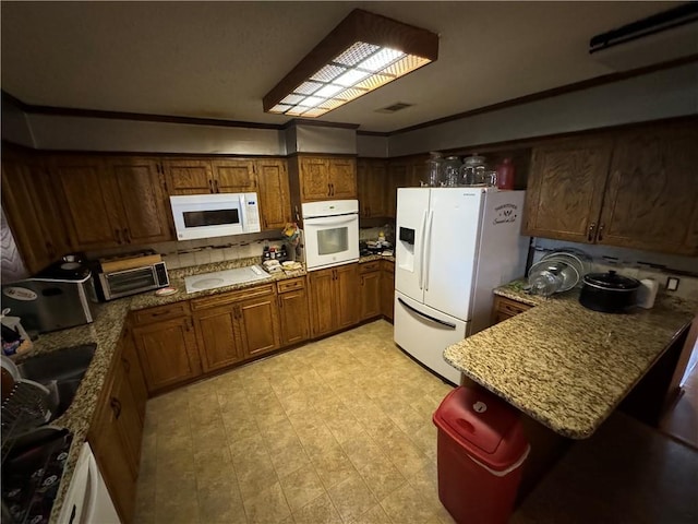 kitchen with kitchen peninsula, sink, white appliances, and ornamental molding