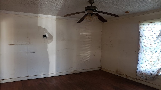 spare room featuring ceiling fan, dark wood-type flooring, and a textured ceiling