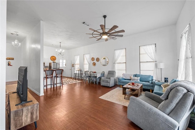 living room with ceiling fan with notable chandelier, dark hardwood / wood-style floors, and a wealth of natural light