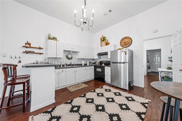 kitchen with white cabinets, decorative backsplash, stainless steel fridge, and black range with electric cooktop