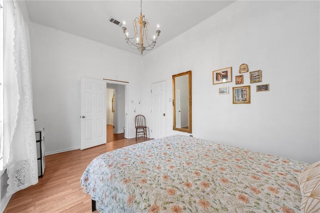 bedroom featuring a notable chandelier and light hardwood / wood-style flooring