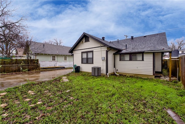 rear view of house with a yard and central AC