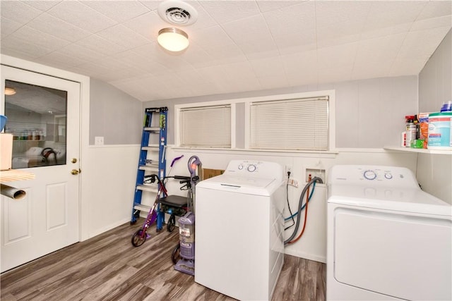 clothes washing area with washer and clothes dryer and wood-type flooring