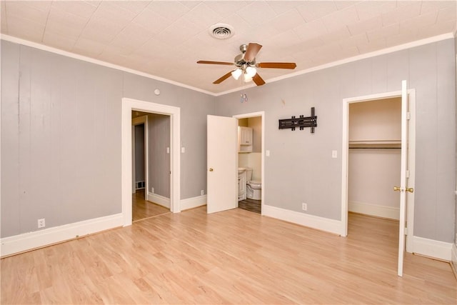 unfurnished bedroom featuring ornamental molding, ceiling fan, light hardwood / wood-style flooring, connected bathroom, and a closet