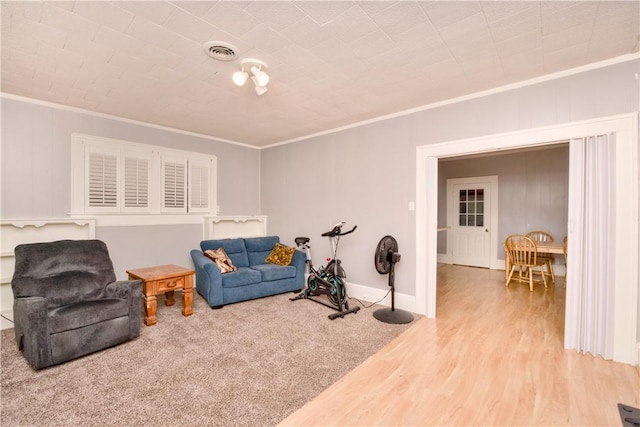 sitting room featuring light wood-type flooring and ornamental molding