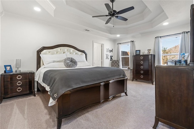 bedroom featuring a tray ceiling, ceiling fan, crown molding, and light carpet